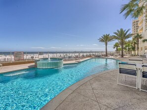 Ein Pool mit Whirlpool, Palmen und Meerblick.