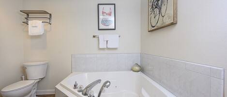 Un baño con inodoro, bañera y zona de ducha.