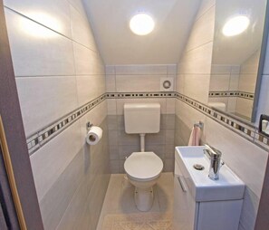 A compact bathroom with a toilet, sink, and mirror. - House 747/1746 (Istria - Stinjan), 1000m from the beach (Stinjan)