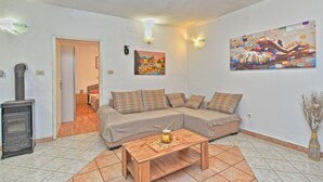 Ein Wohnzimmer mit einer Couch, einem Holztisch, einem Kamin und zwei Wandleuchten.
