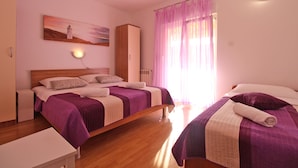 A bedroom with two beds, a wooden wardrobe, a nightstand, and a painting on the wall. - Apartment 768/1789 (Istria - Fažana), 500m from the beach (Fažana)