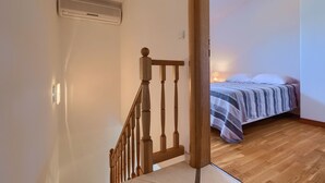 A bedroom with a wooden staircase, a bed with a striped blanket, and a ceiling vent. - Apartment 771/1799 (Istria - Fažana), 300m from the beach (Fažana)