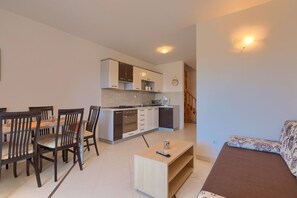 Un appartement moderne comprenant un coin repas, une cuisine et un salon.