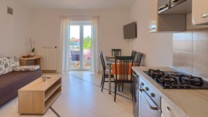 A modern kitchen with a dining area, a sofa, and a TV. - Apartment 771/1799 (Istria - Fažana), 300m from the beach (Fažana)