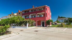 A multi-story residential building with balconies, a gated entrance, and a clear sky. - Apartment 771/1800 (Istria - Fažana), 300m from the beach (Fažana)