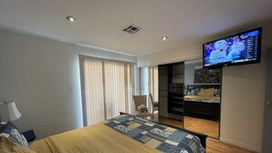A hotel room with a bed, a TV mounted on the wall, a desk, and a chair. - La Cassita Beautiful Condo WOW!!!! (Las Vegas)