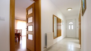 A hallway with a wooden door, a radiator, and a mirror on the wall. - Apartment 777/1811 (Istria - Fažana), 500m from the beach (Fažana)