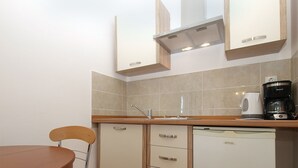 A compact kitchenette with a sink, a coffee maker, and a compact refrigerator.