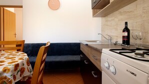 A compact kitchen with a stove, sink, and a clock on the wall. - Apartment 777/1814 (Istria - Fažana), 500m from the beach (Fažana)