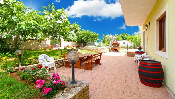 A patio with a table and chairs, a barbecue grill, and a barrel. - Apartment 777/1814 (Istria - Fažana), 500m from the beach (Fažana)