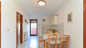 A narrow hallway leading to a dining area with a table and chairs, a radiator, and a door with a window. - Apartment 794/1844 (Istria - Pula), 1500m from the beach (Pula)