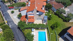 An aerial view of a residential area with a swimming pool, multiple houses with red-tiled roofs, and a street. - Apartment 810/1888 (Istria - Medulin), 600m from the beach (Medulin)