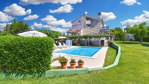 A two-story stone house with a swimming pool, surrounded by well-maintained grass and hedges. - Apartment 810/1888 (Istria - Medulin), 600m from the beach (Medulin)