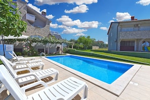 A swimming pool with lounge chairs, a stone building, and a clear blue sky. - Apartment 810/1895 (Istria - Medulin), 600m from the beach (Medulin)