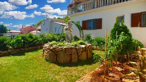 A building with a stone fountain, lush garden, and a balcony with potted plants. - Apartment 811/1894 (Istria - Liznjan), 2500m from the beach (Liznjan)