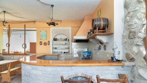A rustic kitchen with a stone wall, wooden bar counter, and a brick oven. - Apartment 811/1894 (Istria - Liznjan), 2500m from the beach (Liznjan)