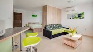 A modern, well-lit room with a bed, a sofa, a coffee table, and a dining area. - Apartment 813/1900 (Istria - Medulin), 90m from the beach (Medulin)