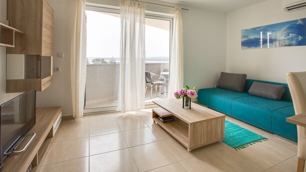 A modern living room with a sofa, coffee table, TV, and a balcony with a view. - Apartment 813/1901 (Istria - Medulin), 90m from the beach (Medulin)