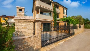 A two-story building with a stone wall and a metal gate. - Apartment 813/1902 (Istria - Medulin), 90m from the beach (Medulin)