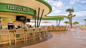 A beachside restaurant named 'Turtles Nest' with outdoor seating and a view of the ocean. - Good Times and Tan Lines! (Daytona Beach)