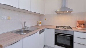A modern kitchen with white cabinets, a stainless steel sink, a built-in oven, and a gas stove. - Apartment 827/1930 (Istria - Medulin), 300m from the beach (Medulin)