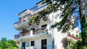 A multi-story building with balconies, outdoor furniture, and greenery. - Studio apartment 828/1937 (Istria - Rabac), 700m from the beach (Rabac)