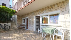 A stone building with a balcony, a bicycle, and a table with chairs outside. - Apartment 847/2001 (Istria - Pula), 800m from the beach (Pula)