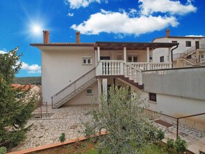 Ein zweistöckiges Gebäude mit einer Steintreppe, die zu einem Balkon führt.