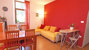 A room with a wooden dining table, chairs, a sofa, and a small table with a plant. - Apartment 849/2007 (Istria - Fažana), 100m from the beach (Fažana)
