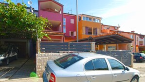 A silver sedan parked in front of a residential building with a garage, a balcony, and a satellite dish. - Apartment 898/2090 (Istria - Pula), 1500m from the beach (Pula)