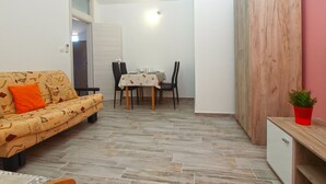 Un espace de vie compact comprenant un canapé, une table à manger, des chaises et un meuble.