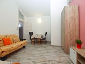 A compact living space with a sofa, dining table, chairs, and a cabinet. - Apartment 898/2092 (Istria - Pula), 1500m from the beach (Pula)