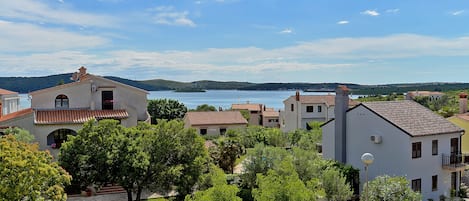 A coastal village with white buildings, a clear blue sky, and a view of the sea.