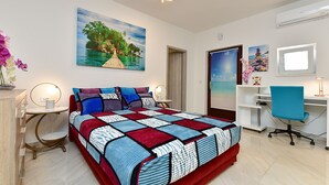 Ein Schlafzimmer mit Bett, Schreibtisch, Stuhl, einem Gemälde und einer Deckenleuchte.