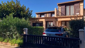 A two-story house with a car parked in the driveway. - Corner house for 5-7 people, Airco, wifi, Residence PORTES DU SOLEIL at 400m from the beach of... (PORTIRAGNES)