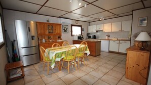 A compact kitchen with a dining table, chairs, a refrigerator, microwave, and a sink. - Corner house for 5-7 people, Airco, wifi, Residence PORTES DU SOLEIL at 400m from the beach of... (PORTIRAGNES)