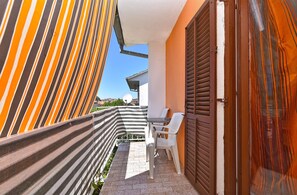 Stroll through this charming outdoor corridor to a patio area with a table and chairs.
