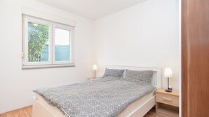 A bedroom with a bed, bedside tables, and a window. - Apartment 928/2196 (Istria - Stinjan), 800m from the beach (Stinjan)