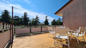 A patio area with a brick floor, white chairs, and a table. - Apartment 930/2214 (Istria - Valbandon), 1000m from the beach (Valbandon)