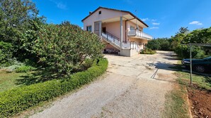A two-story house with a balcony, a driveway, and surrounding greenery. - Apartment 930/2214 (Istria - Valbandon), 1000m from the beach (Valbandon)