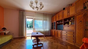 A room with a wooden herringbone floor, a dining table with a lace tablecloth, wooden cabinets, and a chandelier. - Apartment 930/2214 (Istria - Valbandon), 1000m from the beach (Valbandon)