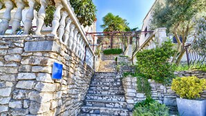 A stone staircase leading to a building with a blue sign indicating an apartment.