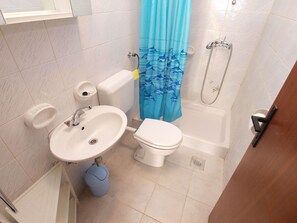 Une salle de bain avec des toilettes, un lavabo et une baignoire.