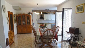 A dining area with a wooden table and chairs, a cabinet, and a sewing machine. - Apartment 961/2448 (Istria - Medulin), 750m from the beach (Medulin)