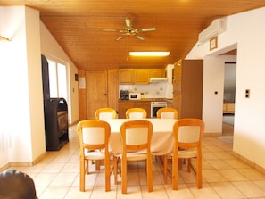 Enjoy meals in this cozy dining area with a round table and six chairs, adjacent to a fully equipped kitchen.