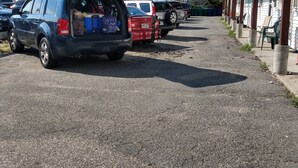 A parking area with vehicles and buildings. - 2 bedrooms with shared pool. apt1 (Hampton)