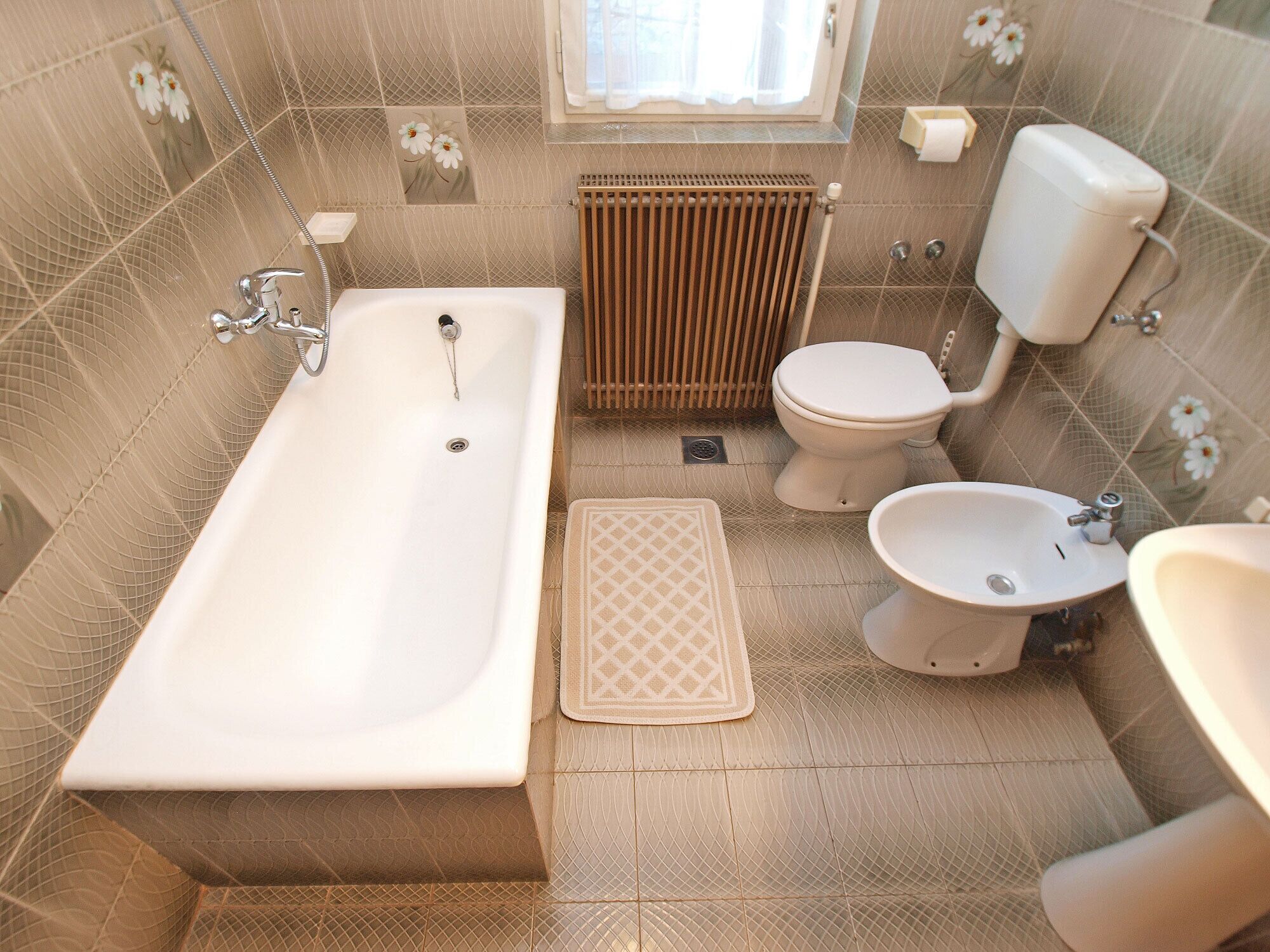 Un baño con bañera, inodoro, bidé y lavamanos.
