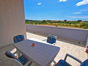 A terrace with a table and chairs, a view of a green landscape, and a clear sky. - Apartment 1002/3282 (Istria - Fažana), 900m from the beach (Fažana)