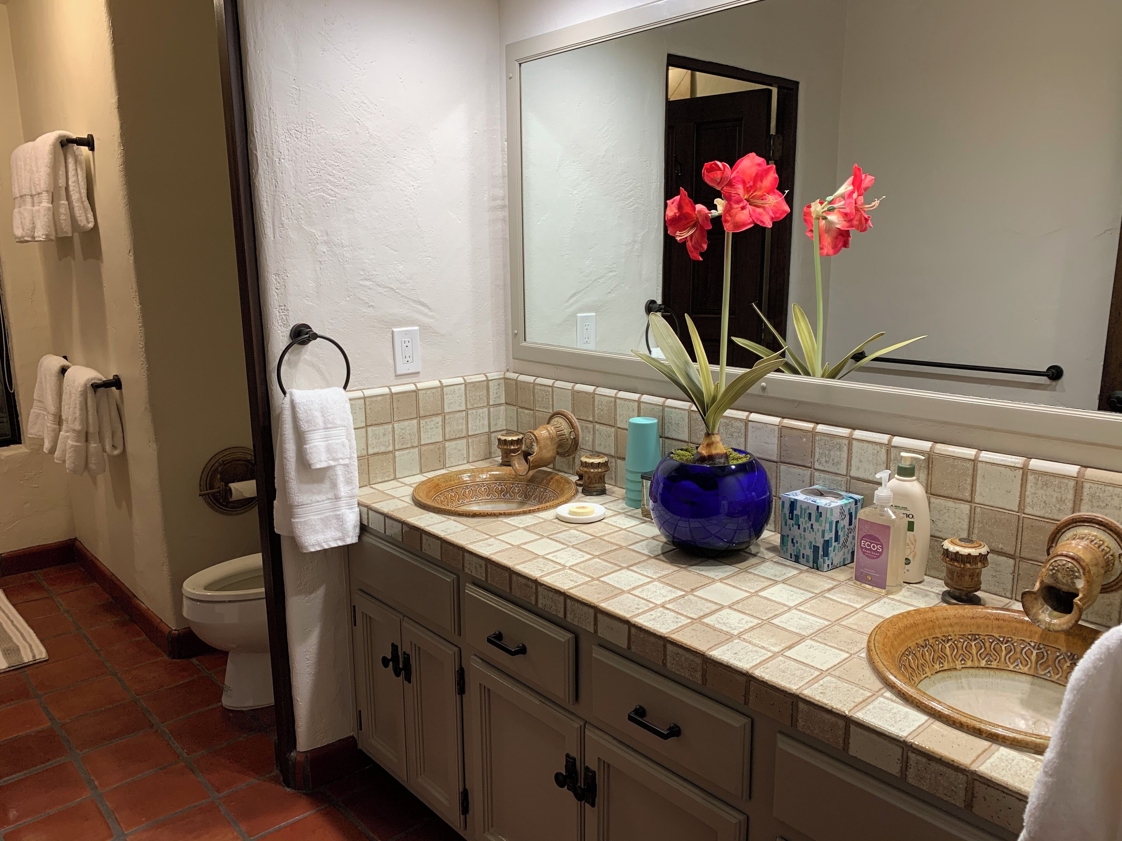 A bathroom with a white sink, a mirror, a towel rack, and a toilet.