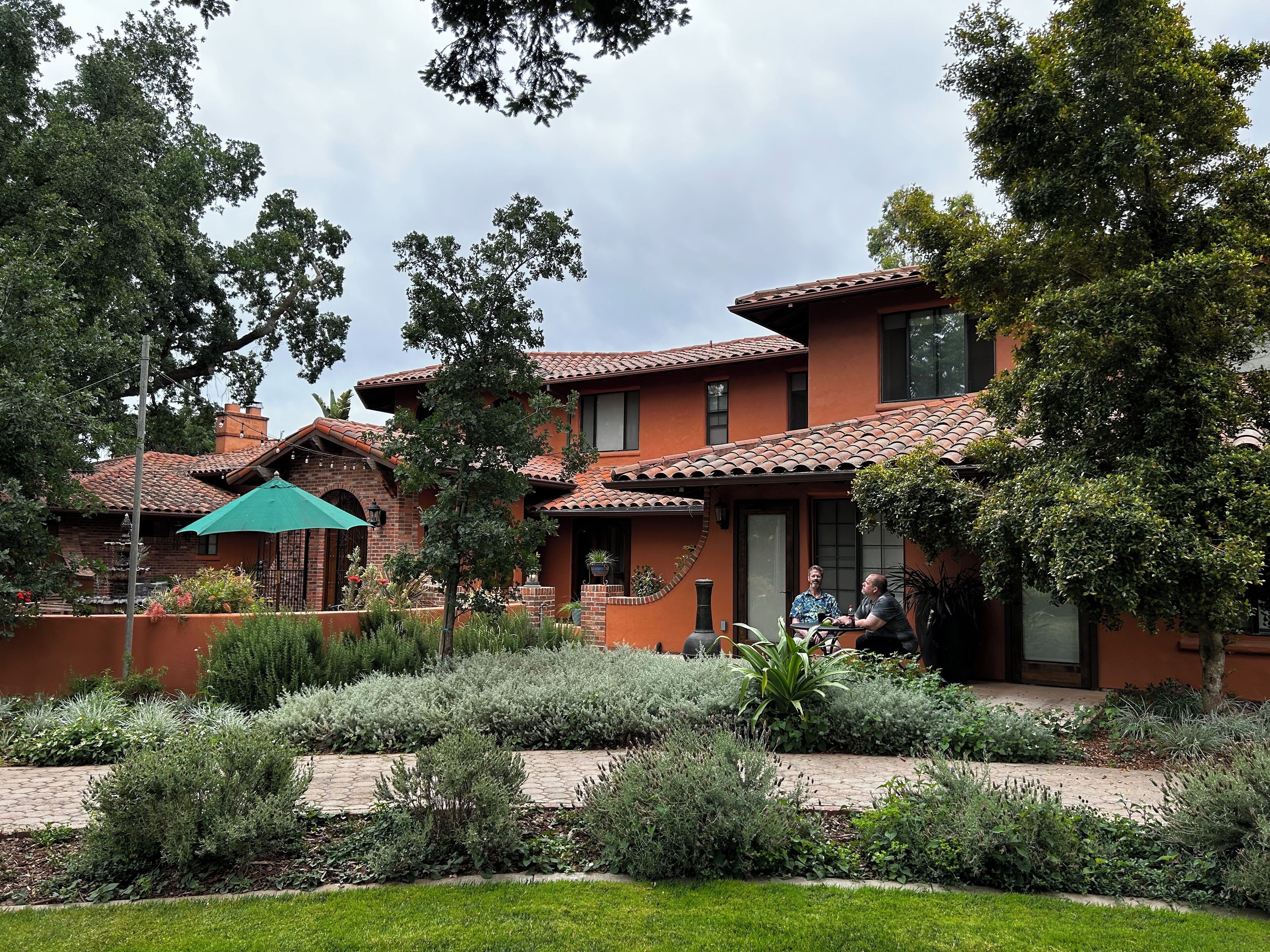 A two-story house with a brick exterior and a tiled roof.